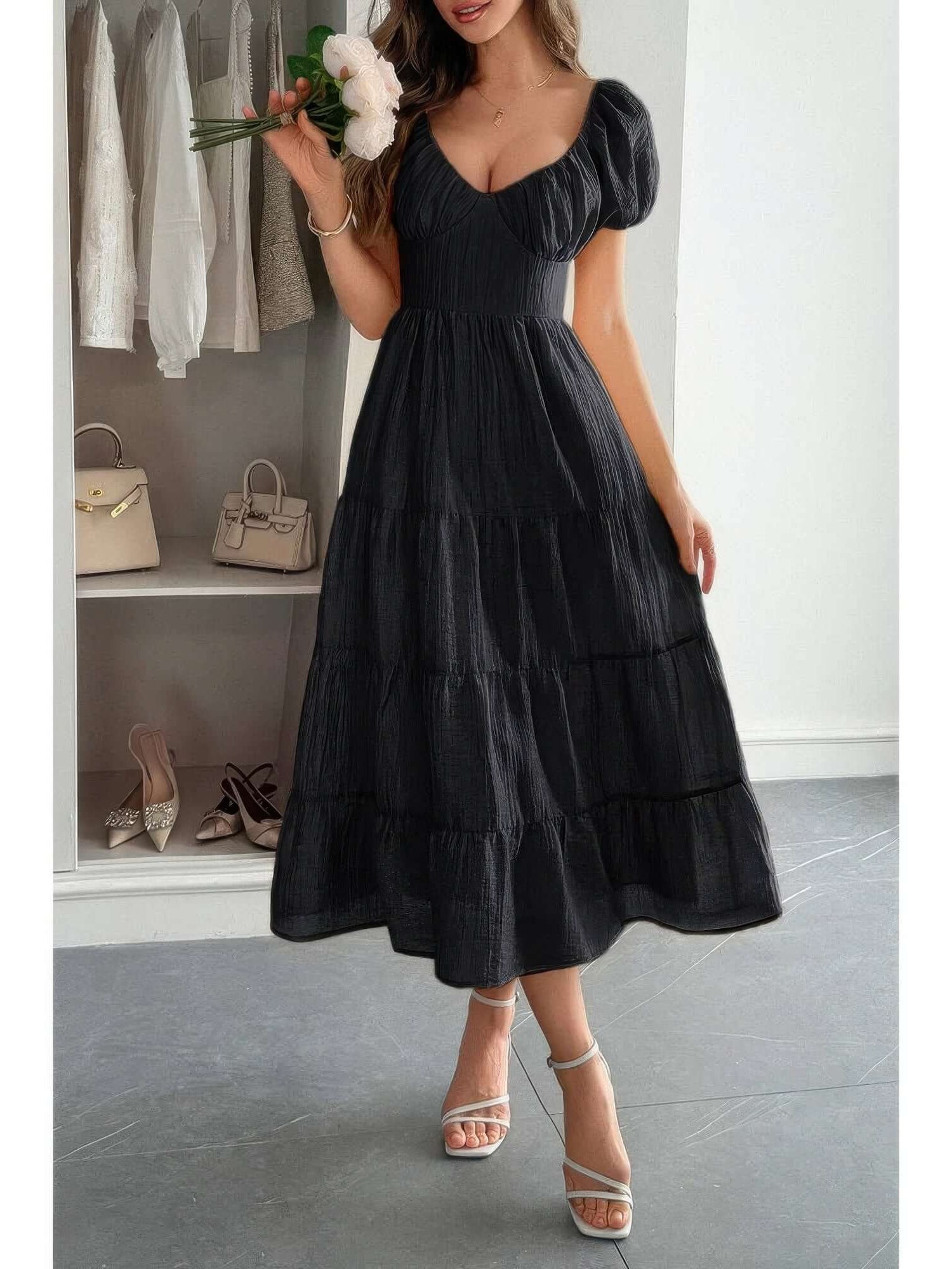 Solid Backless Tiered Puff Sleeve Fit Midi Dress in black displayed elegantly on a model with a bouquet.
