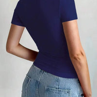 Back view of a woman wearing a Round Neck Short Sleeve T-Shirt in navy blue, paired with jeans.