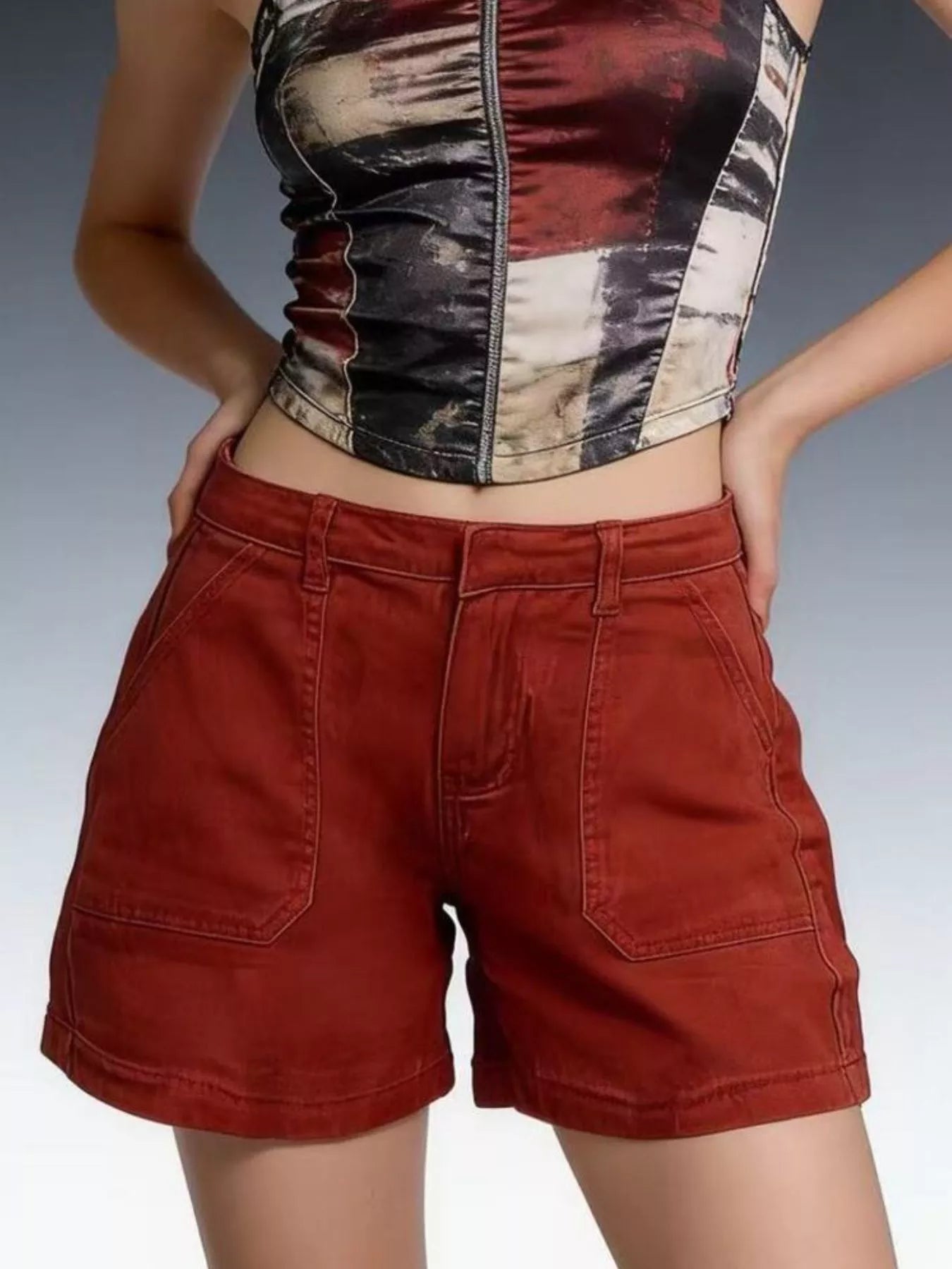 Model wearing Pocketed Denim Shorts with stylish top against gradient background.