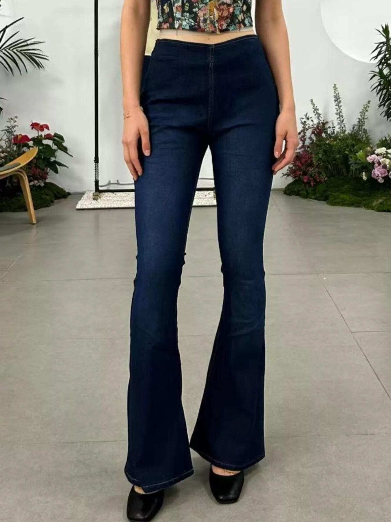 Model wearing High-Waisted Flare Jeans in dark denim, showcasing the pocketed stretch style and flared legs.