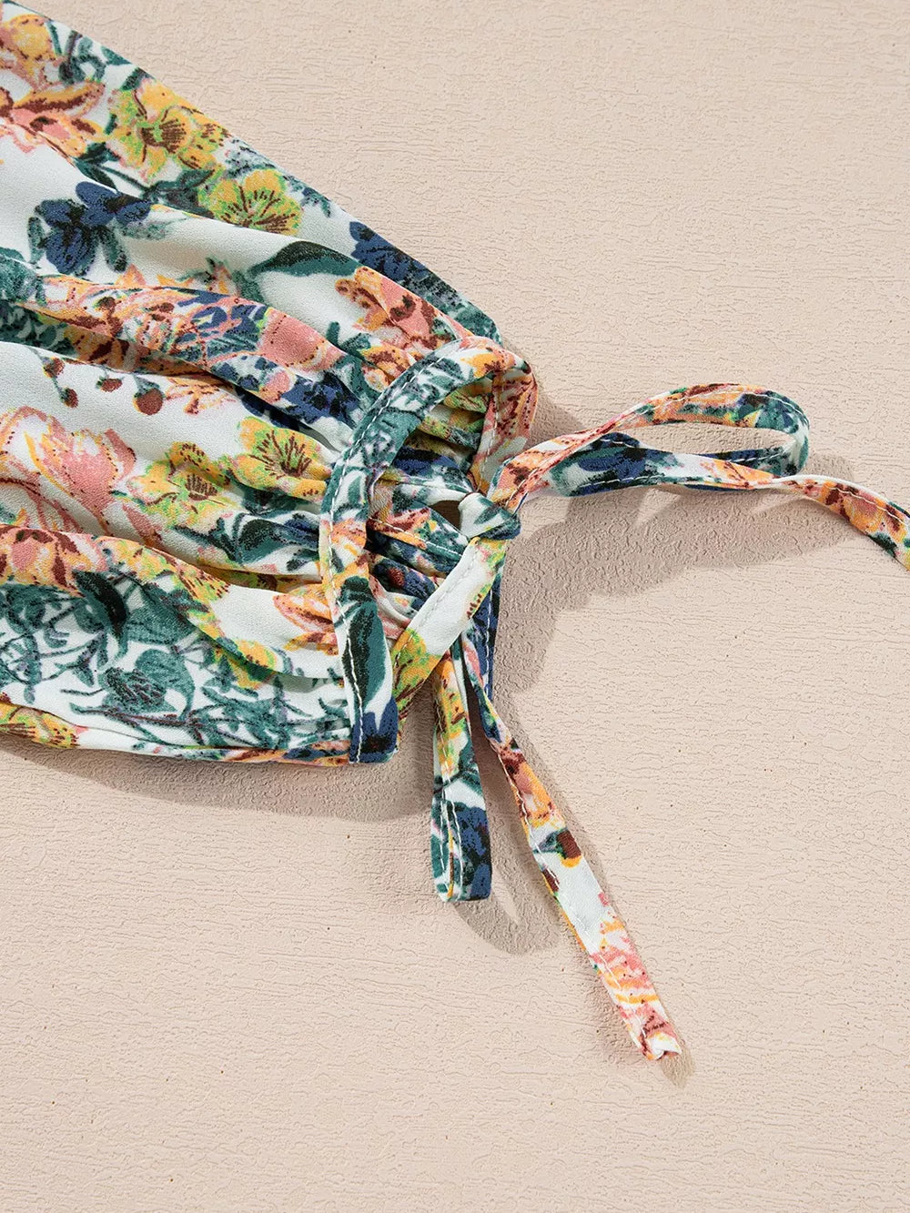 Close-up of the ruffled tie detail on the Floral Print Ruffle Hem Mini Dress.