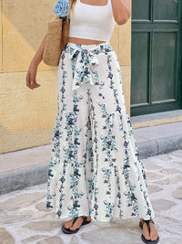 Floral Print Tie Front Wide Leg Pants modeled outdoors with a white crop top and a woven bag.