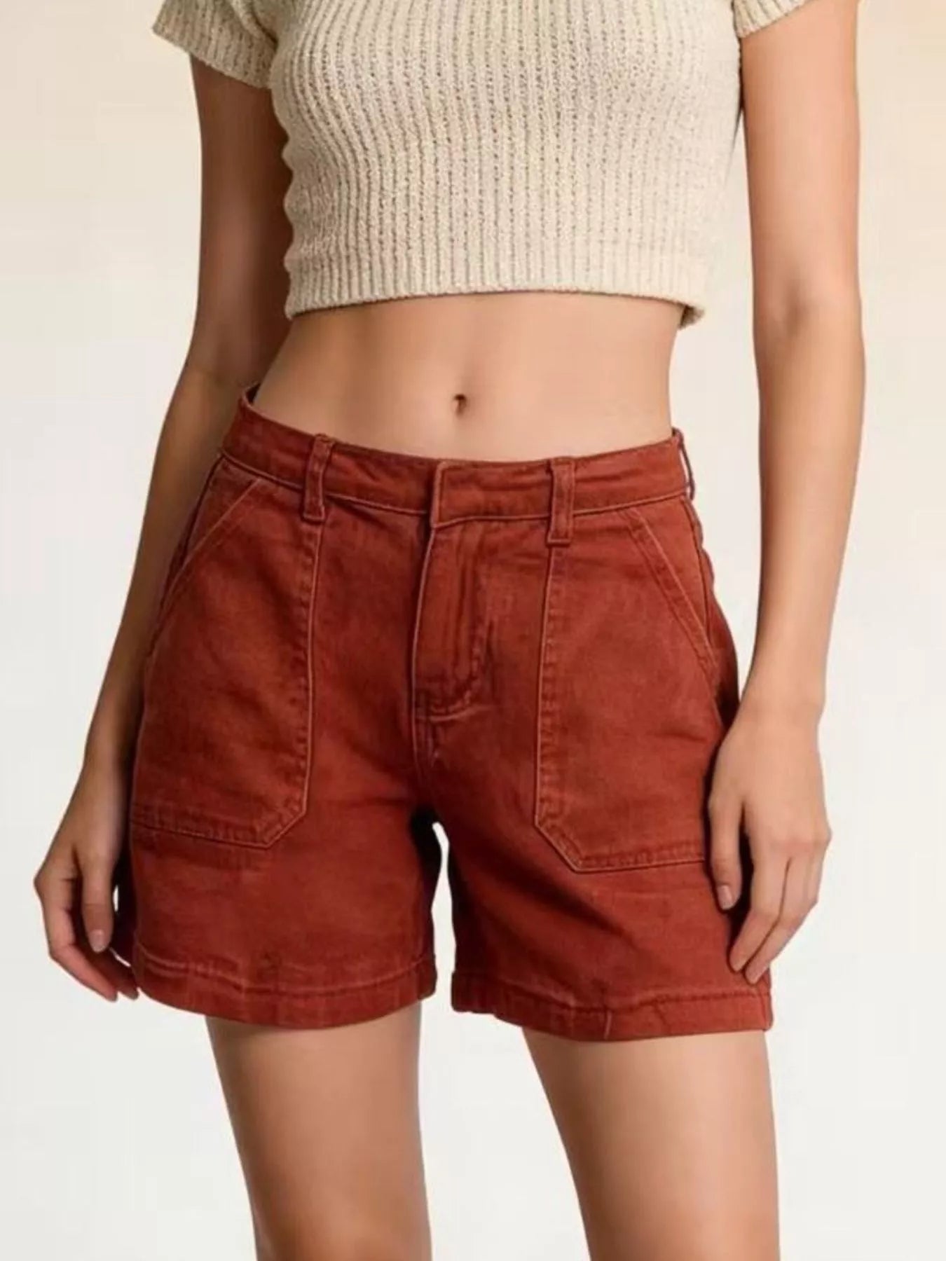 Pocketed Denim Shorts in rust color, featuring pockets and buttoned design, paired with a crop top.