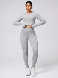 Back Crisscross Round Neck Long Sleeve Top and Leggings Active Set worn by a model in a stylish grey color.