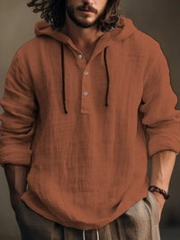 Men's half button hoodie in earthy orange color with long sleeves and a casual style.