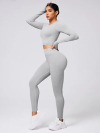 Back Crisscross Round Neck Long Sleeve Top and Leggings Active Set in grey worn by a model showcasing stylish workout wear.