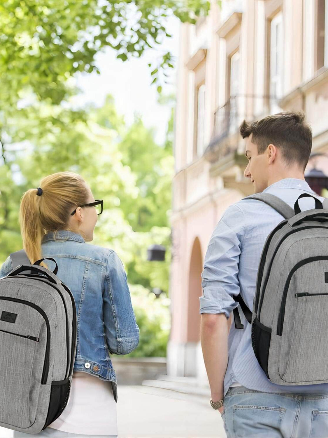 Couple walking in a city with MATEIN grey travel backpacks, ideal for business and college use.