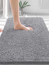 Person stepping onto a soft grey OLANLY bathroom rug, featuring plush chenille texture for comfort and absorbency.
