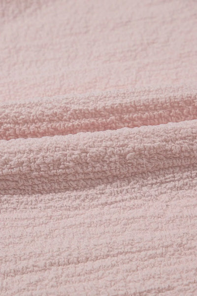 Textured Bow Knot Frilled Butterfly Sleeve Blouse fabric close-up, soft pink material with woven texture.