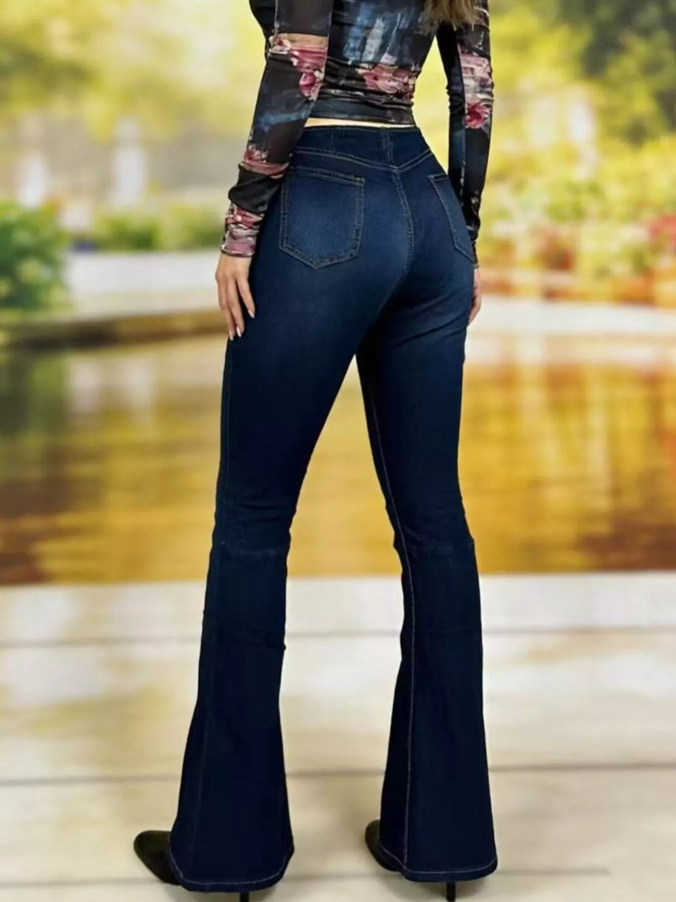 Model wearing High-Waisted Flare Jeans from the back, showcasing flared pant legs and a stylish design.
