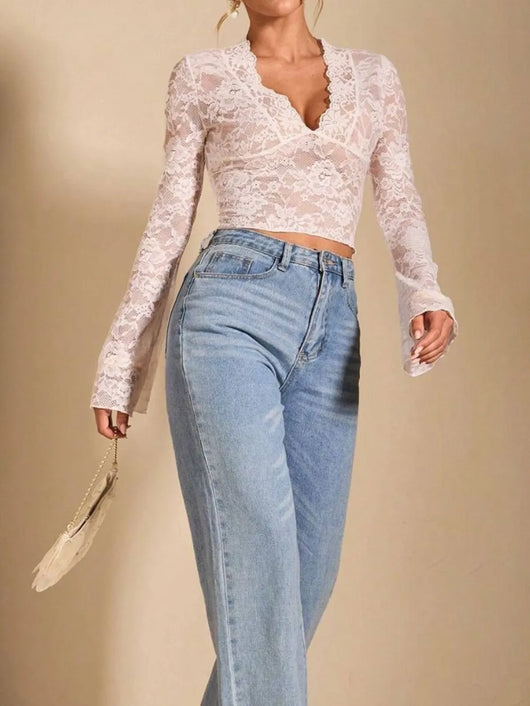 Model wearing V-Neck Flare Sleeve Lace Top with denim jeans, showcasing sheer lace design and stylish sleeves.