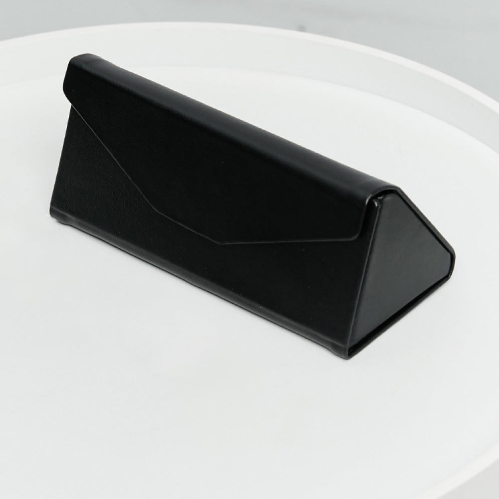 Black geometric eyewear case on a white table.