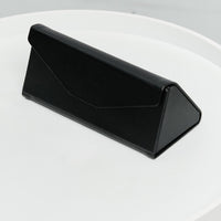 Black geometric eyewear case on a white table.