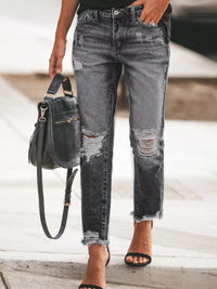 Distressed Wash Ankle Jeans featuring a raw hem, distressed details, and worn look, paired with a stylish bag.
