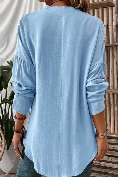 Back view of a woman wearing a Solid Color Notched Long Sleeve Blouse in light blue with long sleeves.