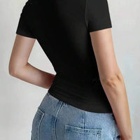 Back view of a woman wearing a Round Neck Short Sleeve T-Shirt in black paired with high-waisted jeans.