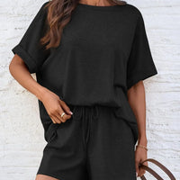 Round Neck T-Shirt and Drawstring Shorts Set featuring a model in a stylish black outfit against a textured background.