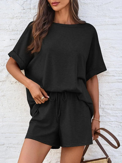 Round Neck T-Shirt and Drawstring Shorts Set featuring a model in a stylish black outfit against a textured background.