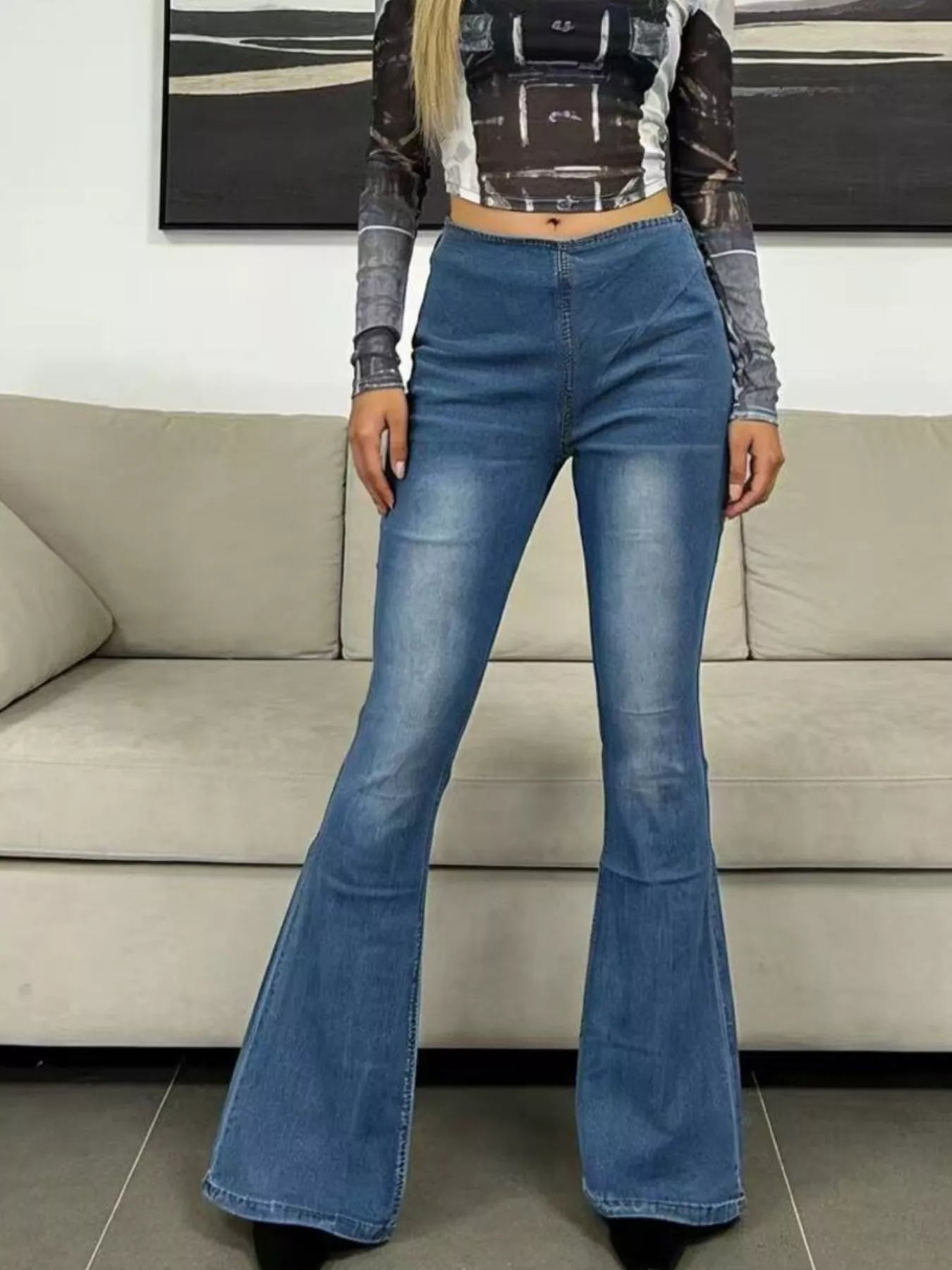 High-Waisted Flare Jeans styled with a fitted top, displayed in a casual indoor setting with a couch.