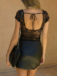 Model wearing Lace V-Neck Slim Fit T-Shirt with back tie detail, showcasing sheer lace and a black skirt.