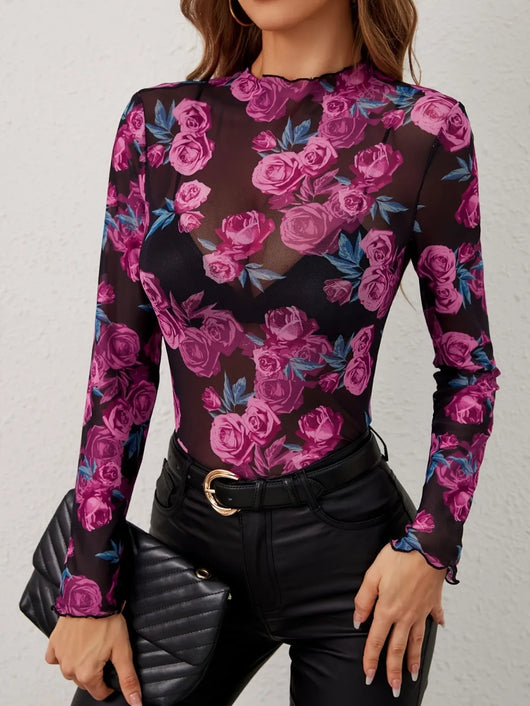 Floral Mock Neck Long Sleeve Top featuring a sheer floral design, model styled with a black handbag and fitted pants.