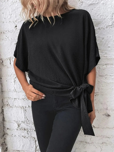 Knotted Round Neck Half Sleeve Blouse showcasing a tied waist detail, styled with black skinny jeans.