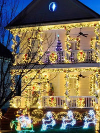 Beautifully decorated house with Christmas lights, wreaths, and a purple tree for festive holiday ambiance.