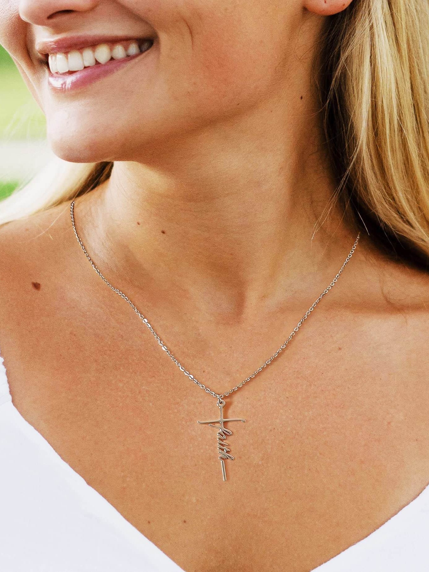 Woman wearing Lcherry Faith cross necklace, showcasing the elegant design and meaningful message of faith.