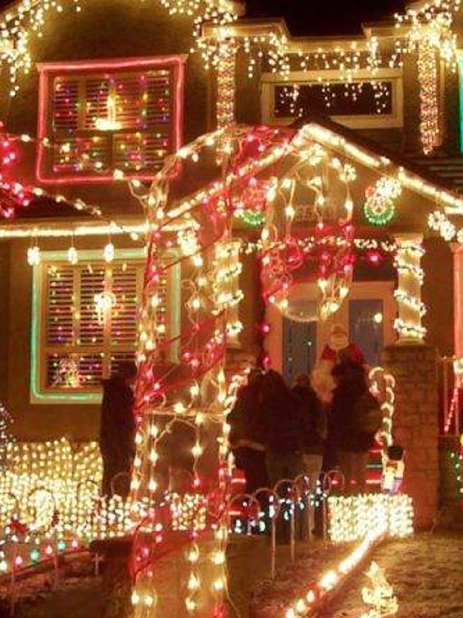 Brightly lit house decorated with colorful Christmas lights and festive decorations, creating a cheerful holiday atmosphere.