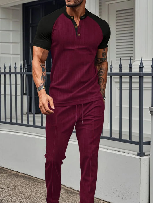Men's Full Size Waffle-Knit Contrast Top and Drawstring Pants Set Plus Size in burgundy and black on a model outdoors.