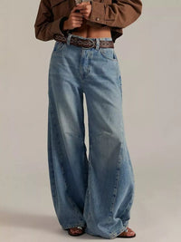 Woman wearing Washed Wide Leg Jeans with cropped top and belt, showcasing relaxed fit and light blue denim.