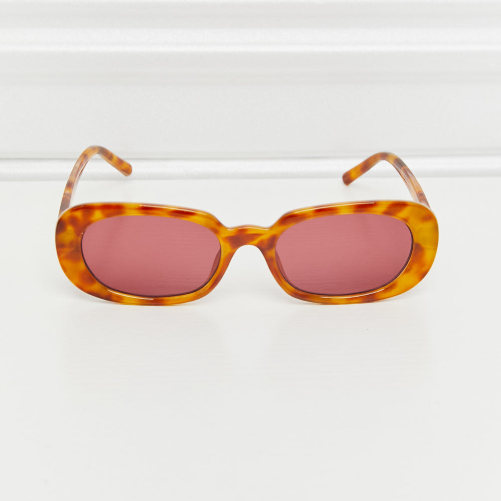 Oval Full Rim Sunglasses with orange tortoiseshell frame and pink lenses on a white background.