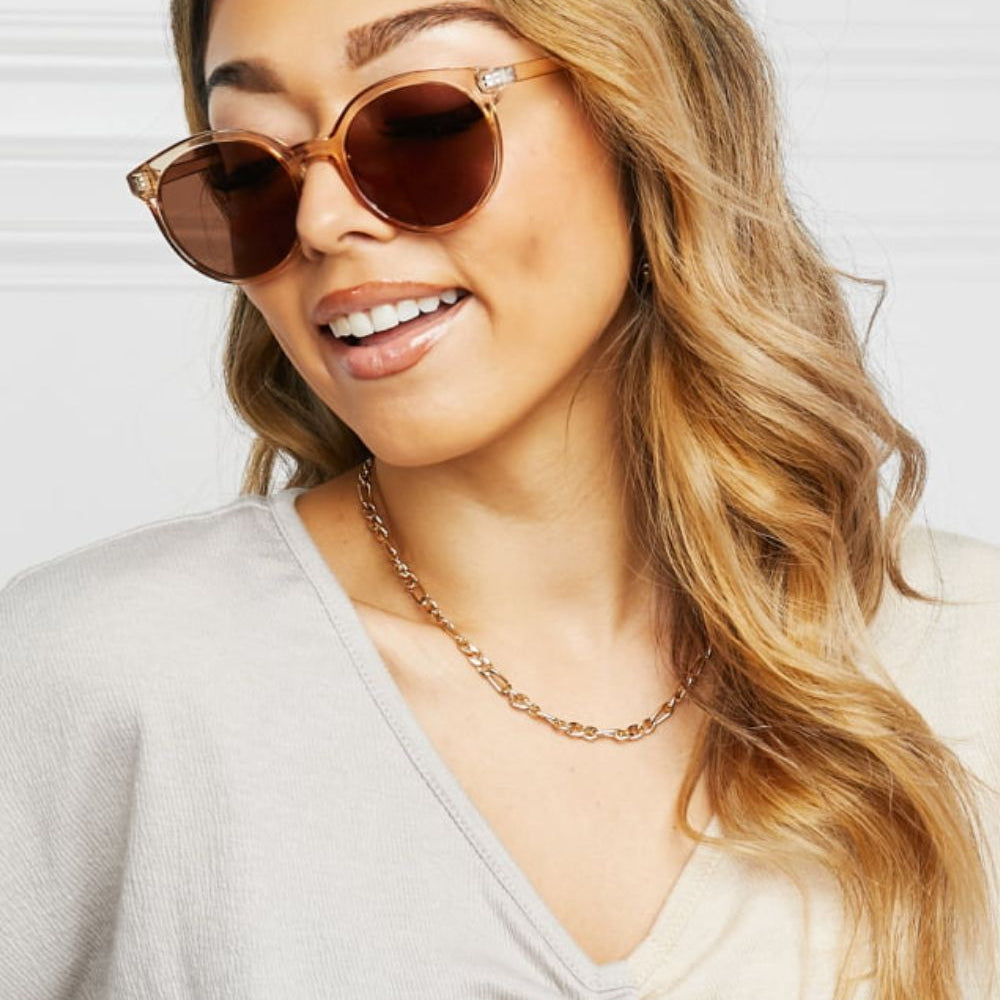 Round Full Rim Polycarbonate Frame Sunglasses worn by a model with long wavy hair, smiling and styled.