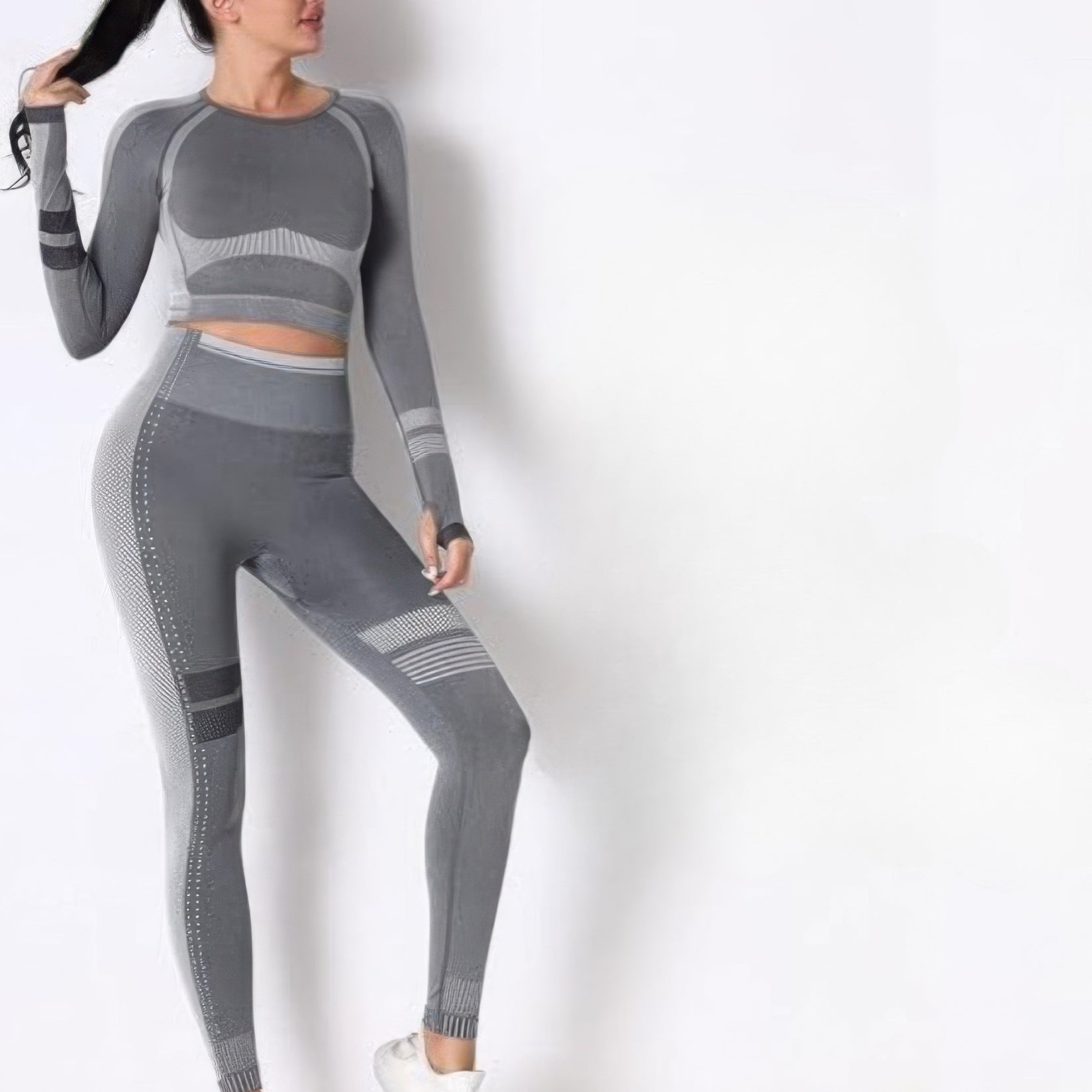 Seamless long sleeve solid yoga set displayed with a model in gray showcasing its body-hugging fit and style.