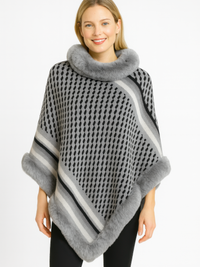 Patterned Knit Poncho With Faux Fur Trim modeled by a smiling woman, featuring a geometric pattern and soft faux fur trim.