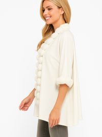 Open-Front Cape With Pom Faux Fur Trim modeled by a woman, featuring a plush trim and stylish silhouette.