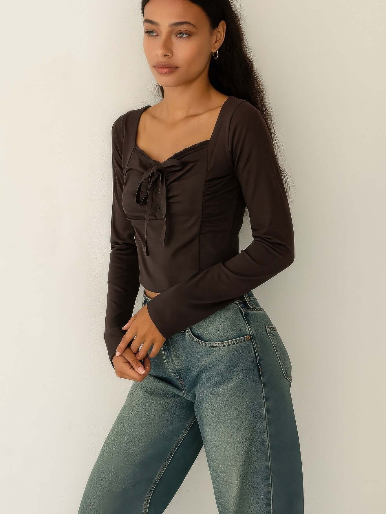 Long Sleeve Scrunch Bow Top worn with high-waisted jeans, showcasing a gathered front and bow accent.