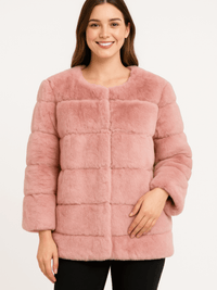 Model wearing a stylish plush camel faux fur jacket with a collarless neckline and horizontal paneling.