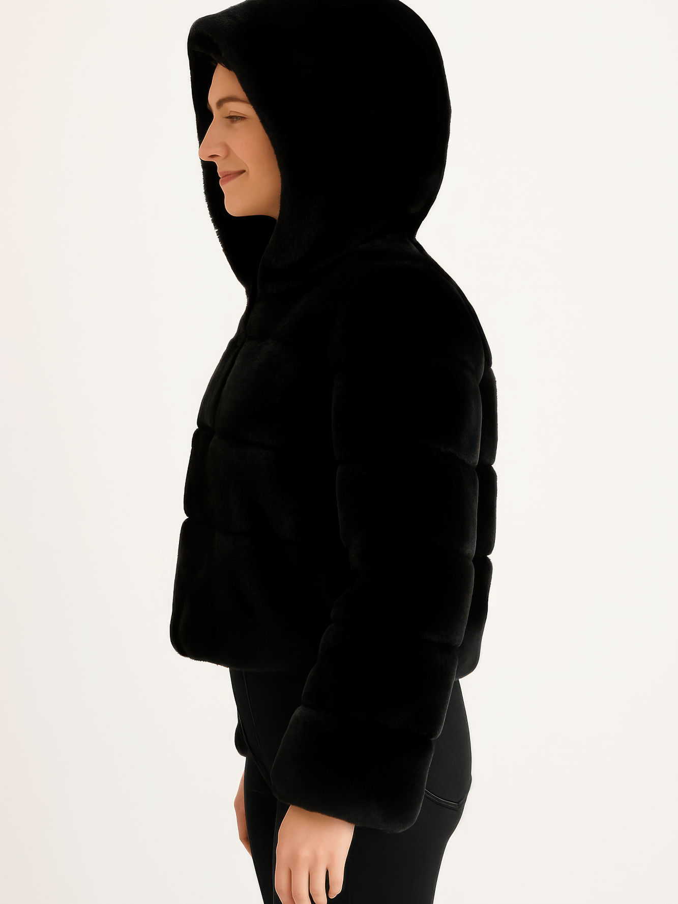 Profile view of a model wearing a black Faux Fur Hooded Jacket with a cozy hood and plush texture.