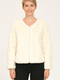 Model wearing a cream faux fur jacket, showcasing soft texture and stylish design in a neutral tone.