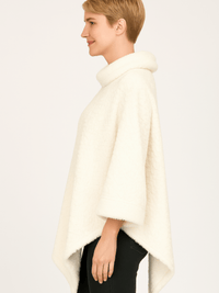 Textured Cowl Neck Poncho in ivory featuring a plush fabric and relaxed silhouette, showcasing a flattering pointed hemline.
