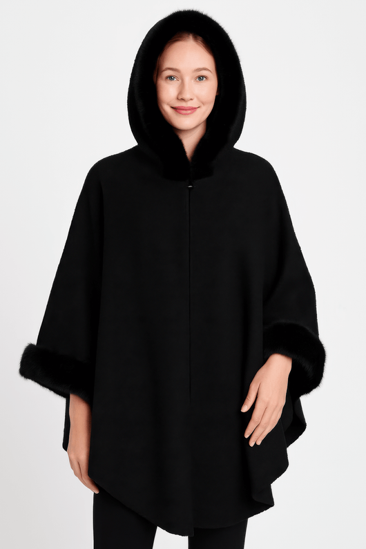 Hooded Faux Fur Trim Cape worn by a woman, showcasing its luxurious black fabric and plush faux fur trim.
