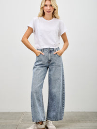 Model wearing High Rise Low Curve Barrel jeans with a white cropped t-shirt and sneakers.