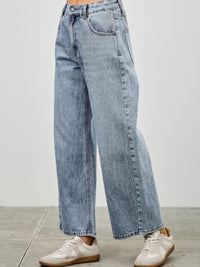 High Rise Low Curve Barrel jeans featuring a high-rise waist and roomy barrel leg, styled with sneakers.