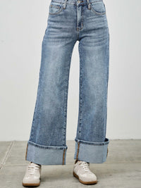 Mid Rise Cuffed Jeans With Stretch in light blue denim, featuring a cuffed hem and paired with stylish sneakers.