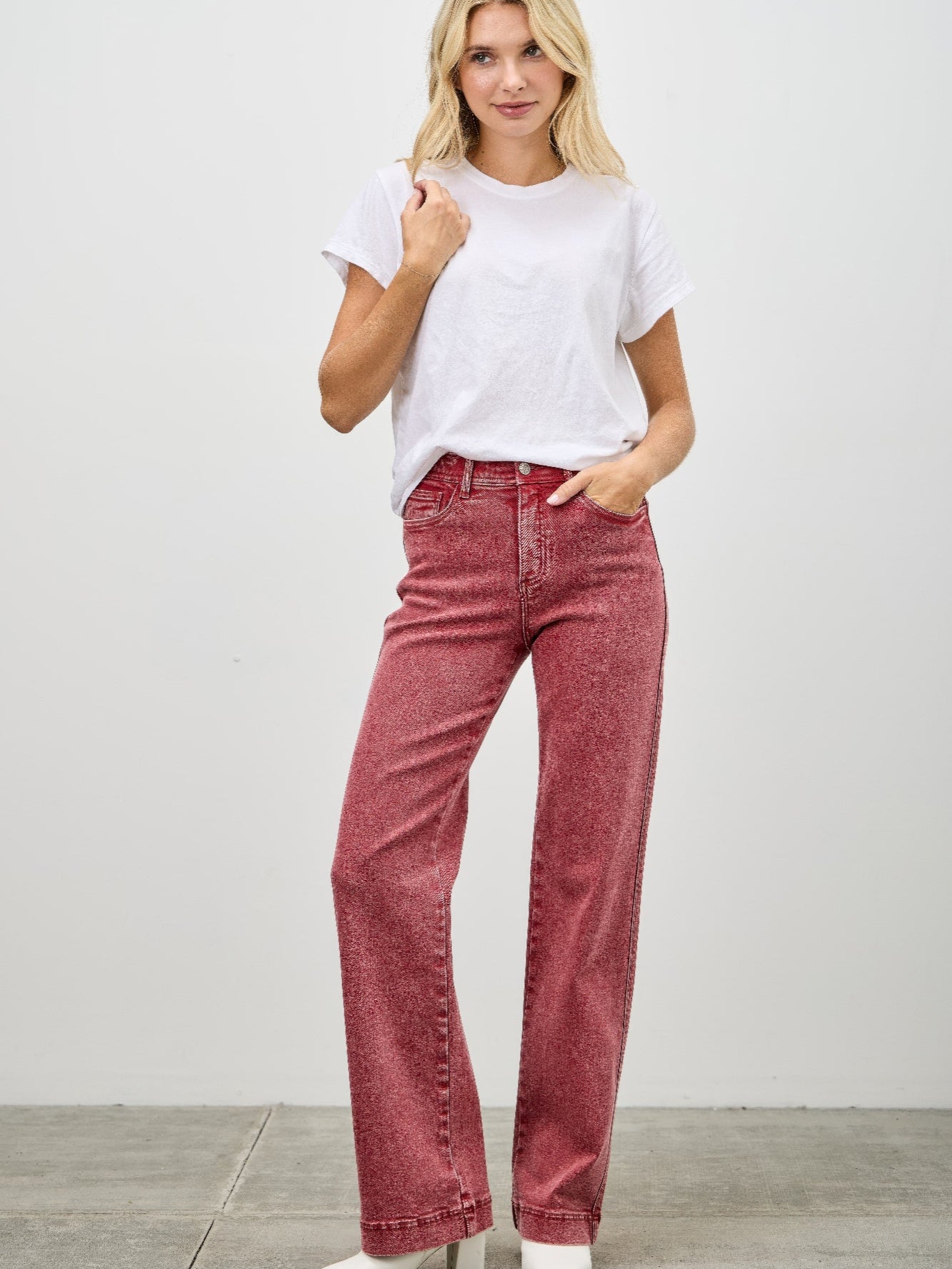Model wearing High Rise Slim Wide Straight jeans in red with a white t-shirt and stylish heels.