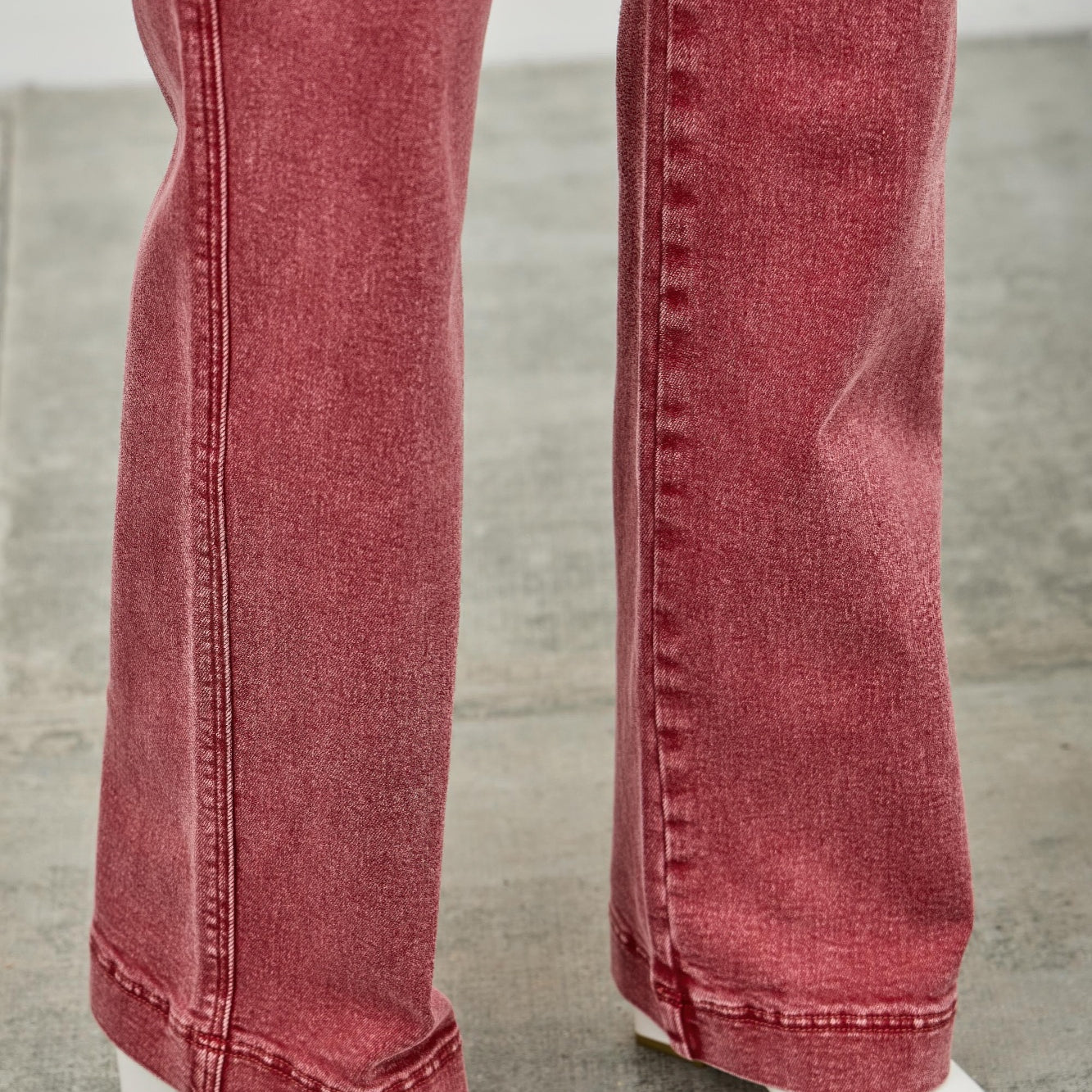 High Rise Slim Wide Straight jeans in red with white ankle boots on a gray floor.