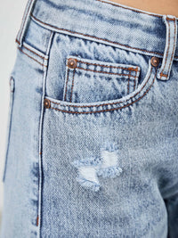 Close-up of mid rise relaxed straight with destroy jeans showcasing distressed detailing and classic stitching.