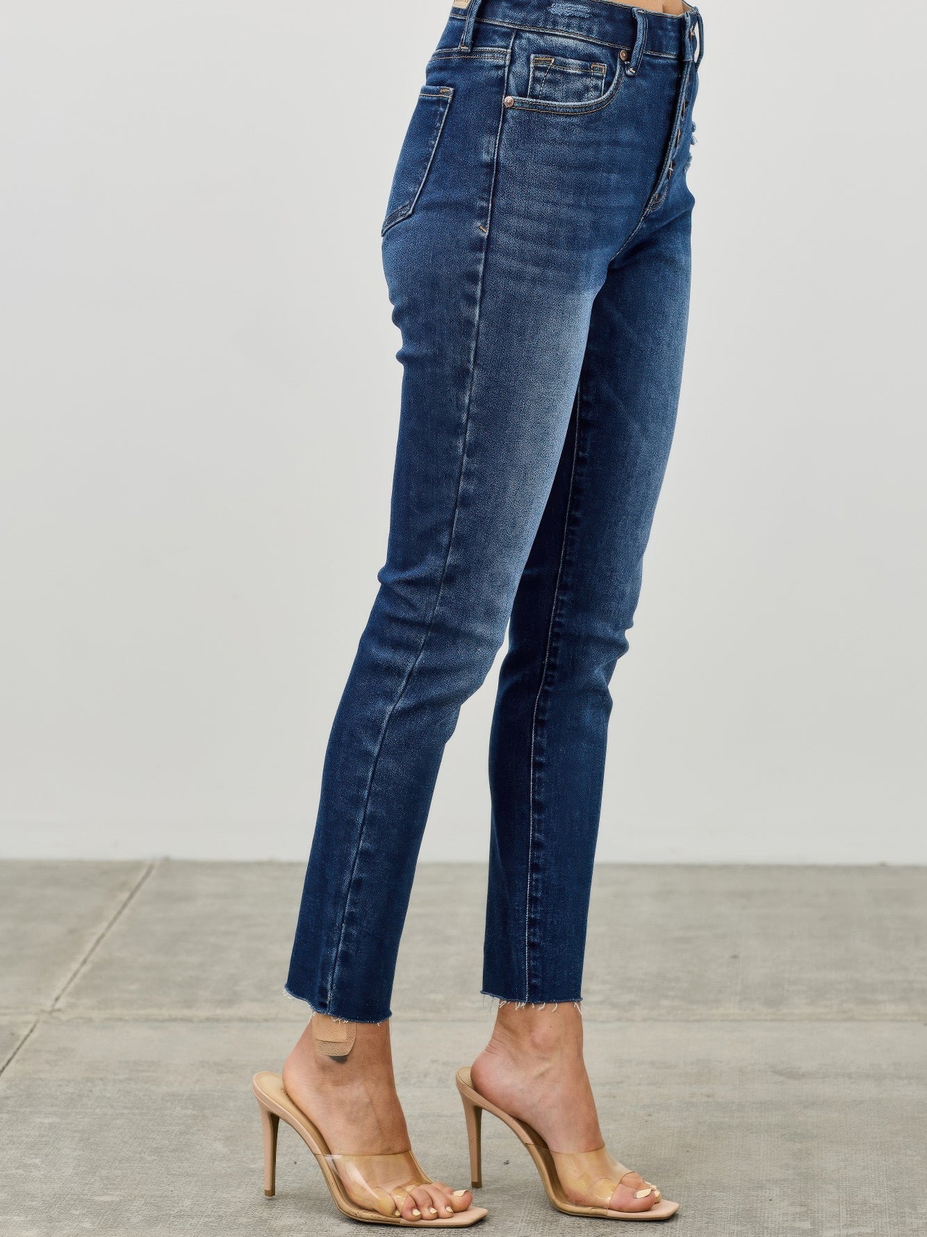 High Rise Ankle Skinny With Button Fly model showcasing form-fitting denim jeans in a stylish pose.