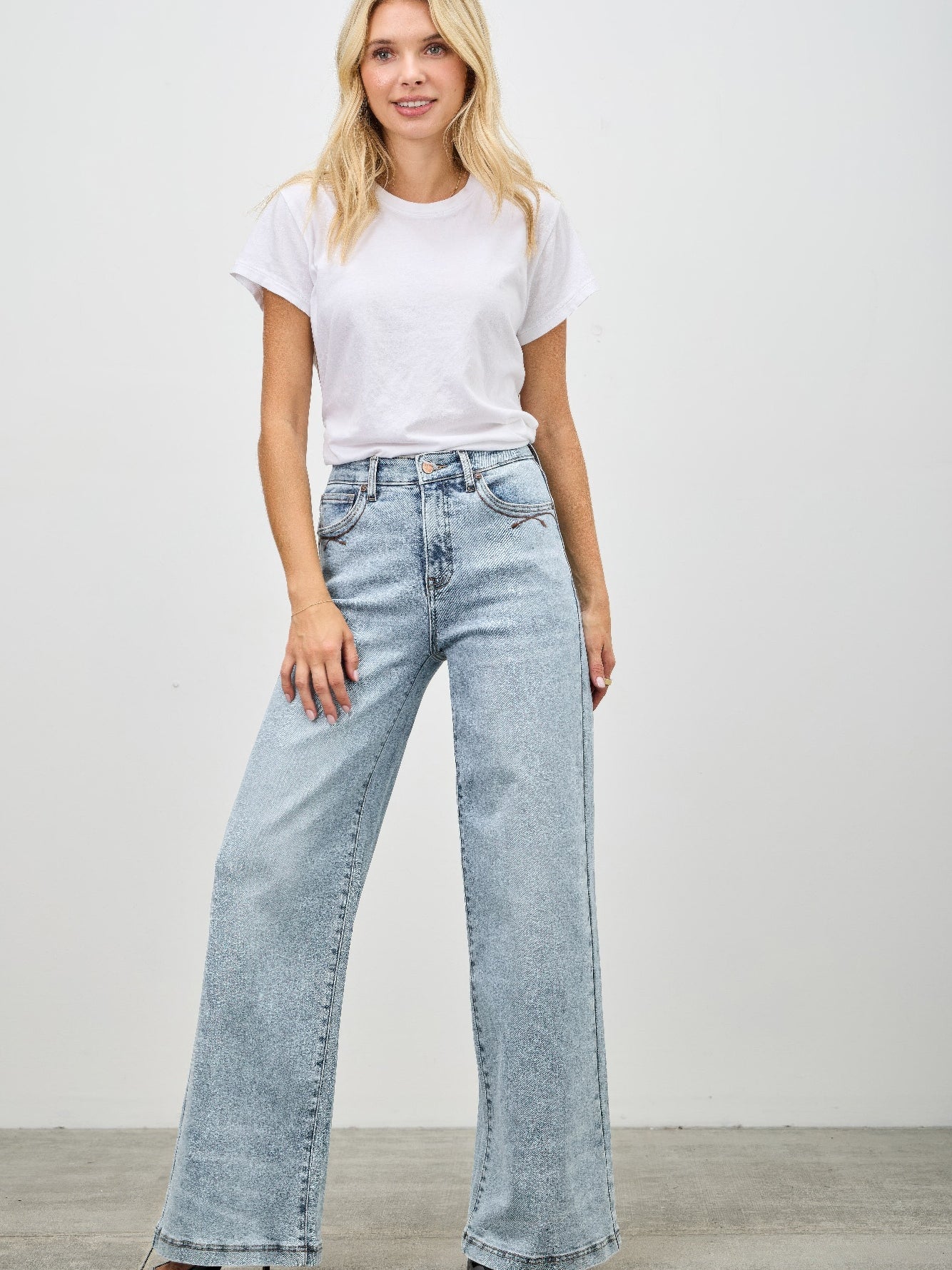 High Rise Wide Leg jeans styled with a white t-shirt for a trendy, casual look.